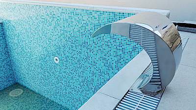 Detalj bazena s inox slapom i tirkiznim mozaikom – Arbeto bazenska oprema