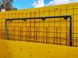 Postavljanje PVC cjevovoda na drvenu oplatu s armaturom tijekom početne faze izgradnje bazena