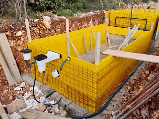 Precizna ugradnja i niveliranje skimera na žutu oplatu s armaturom tijekom izgradnje bazena