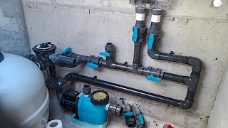 Precizno ugrađen PVC razvod cijevi s plavim ventilima, bazenskom pumpom i pješčanim filterom u strojarnici